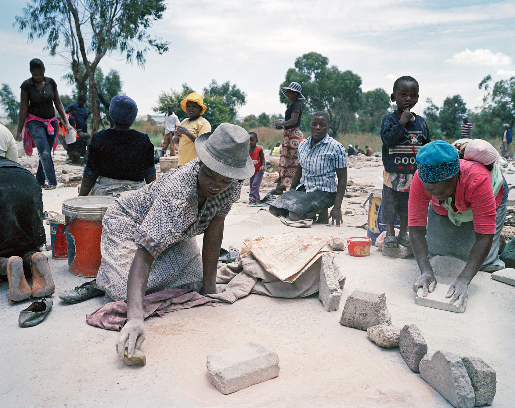 Precious Sibanda, Roodepoort, 2013. Also from Zimbabwe, Sibanda arrived in South Africa a few months before this photo was taken. She was one of several hundred women responsible for grinding rocks excavated by informal gold diggers. © Ilan Godfrey, “Legacy of the Mine”.