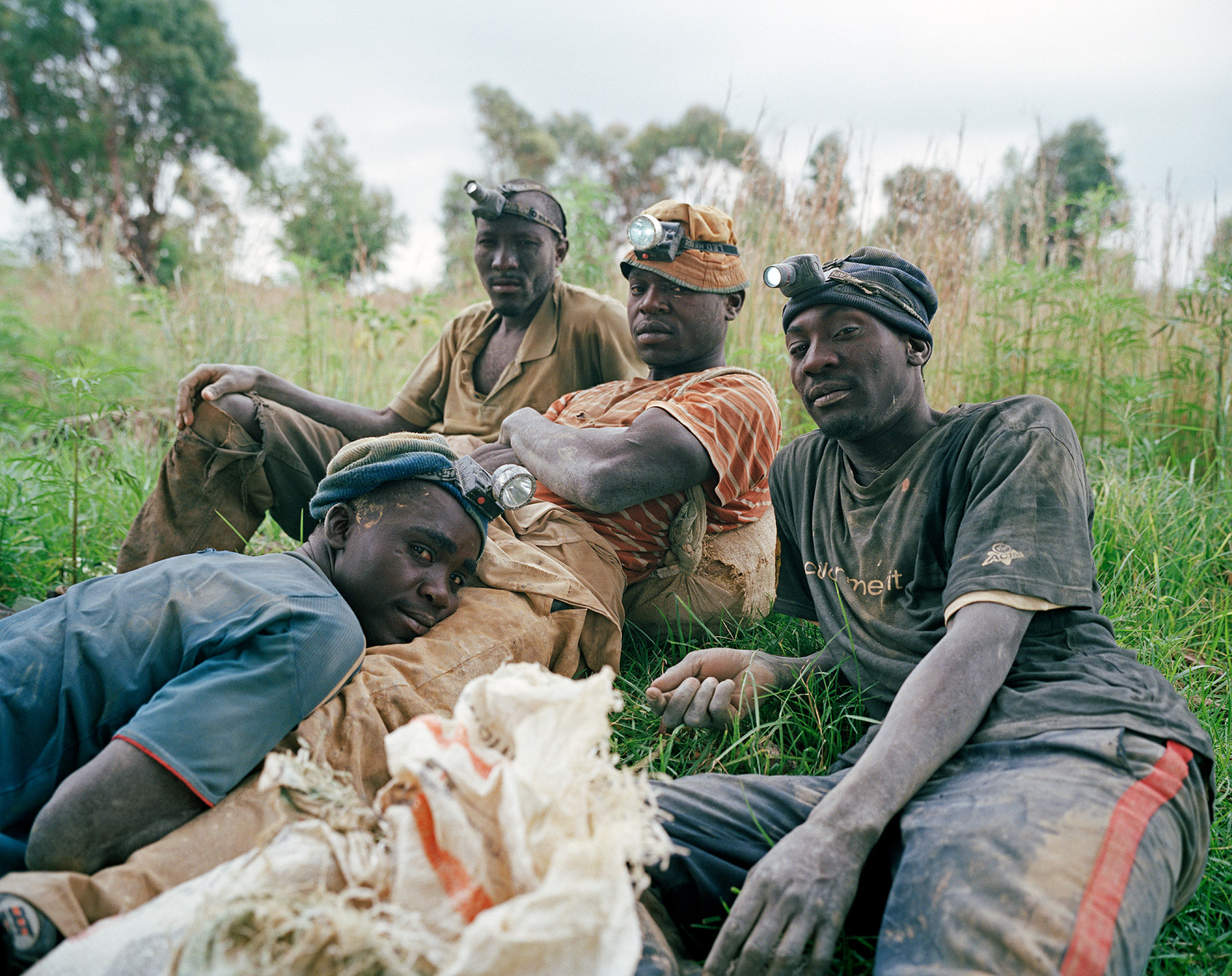 Linda Ndlovu, Danie lMandlo, Dumisani Mahlangu, and Calvin Sibanda, 2013. These four Zimbabwean men, writes photographer Ilan Godfrey, were “highly skilled informal diggers with many years of experience,” respected in their communities for their courage and skills. Godfrey visited their worksite many times to build up the trust required to photograph and name them. © Ilan Godfrey, "Legacy of the Mine".
